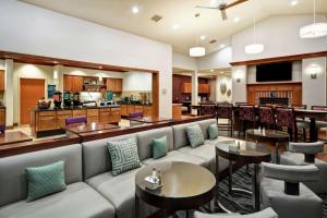 um restaurante com sofás e mesas e um bar em Homewood Suites by Hilton Cincinnati-Milford em Milford