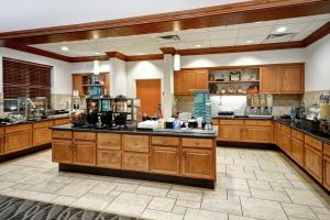 a large kitchen with wooden cabinets and counters at Homewood Suites by Hilton Cincinnati-Milford in Milford