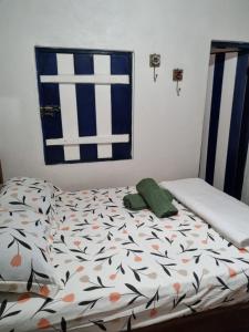 um quarto com uma cama com lençóis estampados com flores em CASINHA AZUL/PIRINOPOLIS em Pirenópolis