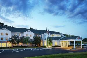 a large white building with a parking lot at Hilton Garden Inn Cincinnati Northeast in Loveland