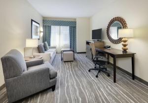 una sala de estar con sofá y escritorio en una habitación de hotel en Homewood Suites by Hilton Dallas/Allen, en Allen