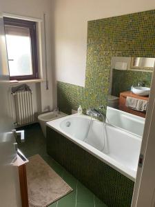 La salle de bains est pourvue d'une baignoire, d'un lavabo et de toilettes. dans l'établissement Appartamento incantevole a due passi dal borgo, à Montesilvano