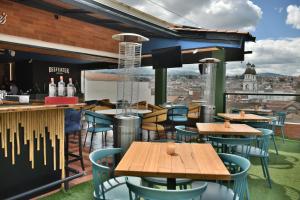 a restaurant with tables and chairs and a view of the city at Hotel Vaway in Cuenca