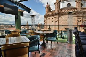 a restaurant with tables and chairs in front of a building at Hotel Vaway in Cuenca