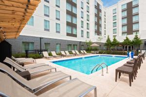 a swimming pool with lounge chairs and a building at Homewood Suites by Hilton Little Rock Downtown in Little Rock