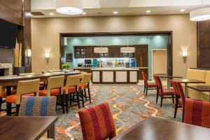 ein Restaurant mit Tischen und Stühlen und eine Bar in der Unterkunft Homewood Suites by Hilton Little Rock Downtown in Little Rock