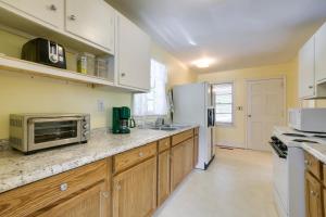 a kitchen with wooden cabinets and a white refrigerator at Fayetteville Vacation Rental about 6 Mi to Downtown! in Fayetteville