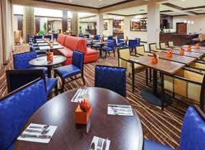 une salle à manger avec des tables et des chaises bleues dans l'établissement Hilton Garden Inn Midland, à Midland