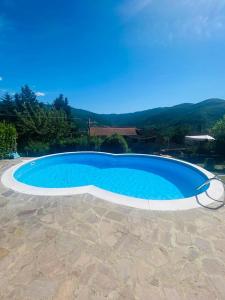 a large blue swimming pool in front of a house at Yurta con uso piscina e vista meravigliosa in Dicomano