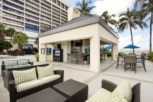 a patio with chairs and tables and a building at Hilton Miami Airport Blue Lagoon in Miami