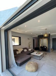 ein Wohnzimmer mit einem Sofa und einem Tisch in der Unterkunft Villa dans les hauteurs de Marseille in Marseille