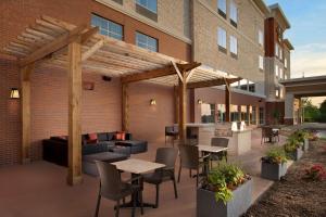 a patio with tables and chairs in front of a building at Homewood Suites By Hilton Kansas City Speedway in Kansas City