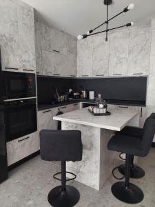 cocina con mesa y 2 taburetes en Апартамент Слави en Blagoevgrad