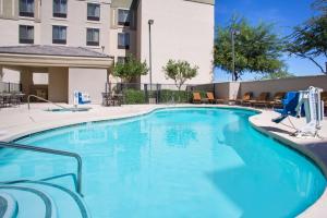 una gran piscina azul con sillas y un edificio en Homewood Suites by Hilton Phoenix-Avondale, en Avondale