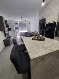 cocina y sala de estar con barra y sillas en Апартамент Слави en Blagoevgrad