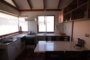 uma cozinha com um lavatório e um fogão forno superior em Posada del Jinete em San José de Maipo