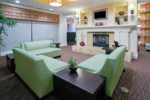 a lobby with green furniture and a fireplace at Hilton Garden Inn Phoenix/Avondale in Avondale
