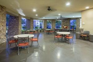a restaurant with tables and chairs and a bar at Hilton Garden Inn Phoenix/Avondale in Avondale