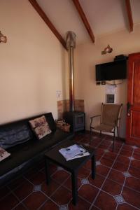 a living room with a couch and a stove at Posada del Jinete in San José de Maipo