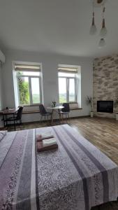 a large white room with a large bed and chairs at Апартаменти біля Фортеці in Kamianets-Podilskyi
