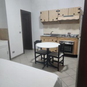 eine Küche mit einem Tisch, 2 Stühlen und einem Waschbecken in der Unterkunft La Pace Case vacanza in Campora San Giovanni