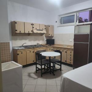 eine Küche mit Holzschränken, einem Tisch und einer Spüle in der Unterkunft La Pace Case vacanza in Campora San Giovanni