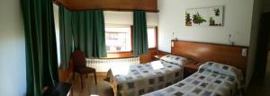 une salle d'hôpital avec deux lits et une table dans l'établissement La Muralla, à Retortillo de Soria