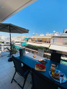een blauwe tafel met eten op het balkon bij 2 BD Top Floor Aprt with Acropolis view in Athene
