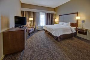 a hotel room with a bed and a flat screen tv at Hampton Inn Dunn in Dunn