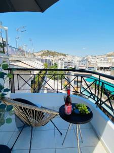 een fles wijn op een tafel op een balkon bij 2 BD Top Floor Aprt with Acropolis view in Athene