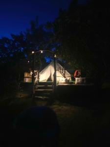 a tent is lit up in the dark at night at Yurta con uso piscina e vista meravigliosa in Dicomano