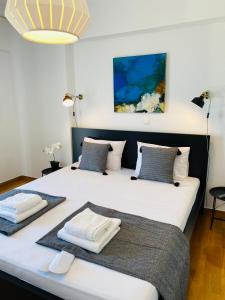 een slaapkamer met 2 bedden en handdoeken bij 2 BD Top Floor Aprt with Acropolis view in Athene