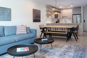 a living room with a blue couch and tables at Forever Young by Revelstoke Vacations in Revelstoke