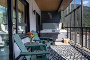 a porch with two chairs and a grill at Forever Young by Revelstoke Vacations in Revelstoke