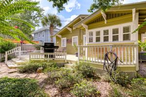 a yellow house with a porch and a grill at Charming St Petersburg Bungalow 2 Mi to Downtown! in St Petersburg