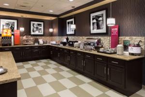a large kitchen with black cabinets and a checkered floor at Hampton Inn Troy in Troy