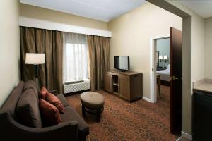 a hotel room with a couch and a television at Hampton Inn Troy in Troy