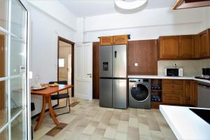 a kitchen with a stainless steel refrigerator and a table at Villa Komorebi, the Private 3BR Grand Estate - 2500m2 Garden - Walk to Beach & Town in Ierapetra