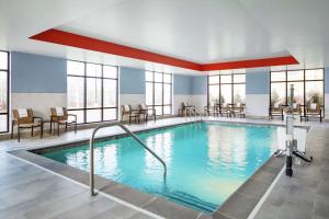 a pool in a hotel room with tables and chairs at Hampton Inn & Suites Chicago/Waukegan in Waukegan