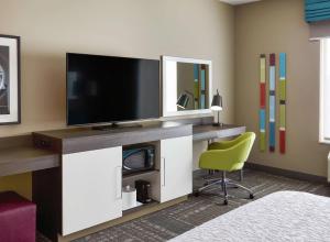 een hotelkamer met een televisie en een stoel bij Hampton Inn & Suites Chicago/Waukegan in Waukegan