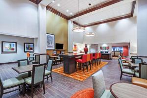 a restaurant with tables and chairs and a bar at Hampton Inn & Suites Houston I-10 West Park Row, Tx in Katy