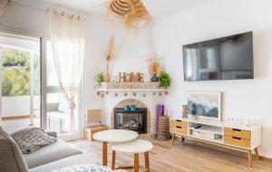 een woonkamer met een open haard en een televisie bij Villa Freyer DeLux Benitachell by Nora Nice in Cumbre del Sol