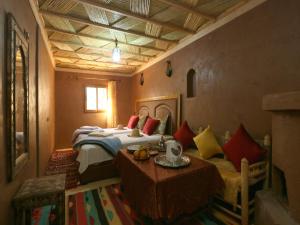 a bedroom with a bed and a table in it at RiadAtlasChateau in Imlil