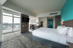 リマにあるホリデイ イン リマ エアポートのベッド1台、薄型テレビが備わるホテルルームです。