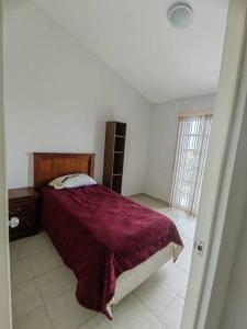 una camera con un letto con copriletto rosso di Agradable casa para descansar en Villas de Campo a Calimaya de Díaz González