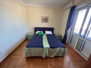 a bed in a room with a large window at Apartments Villa Pržno in Sveti Stefan