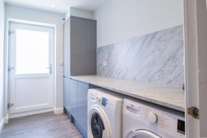a laundry room with a washer and dryer at Amazing 5bed, Free Parking Short and long term stays in Burton upon Trent
