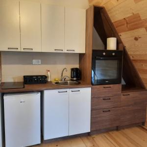 a small kitchen with a sink and a microwave at Zelenova koliba in Žabljak +29 photos