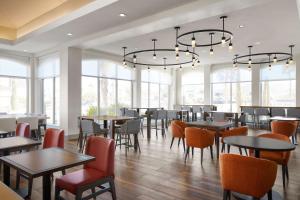 a restaurant with tables and chairs and windows at Hilton Garden Inn Las Vegas/Henderson in Las Vegas