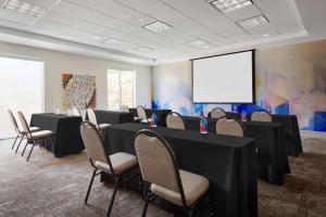 a conference room with tables and chairs and a screen at Hilton Garden Inn Las Vegas/Henderson in Las Vegas